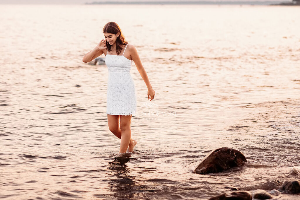 girl in white dress walking in the water at the beach, CT senior photographer