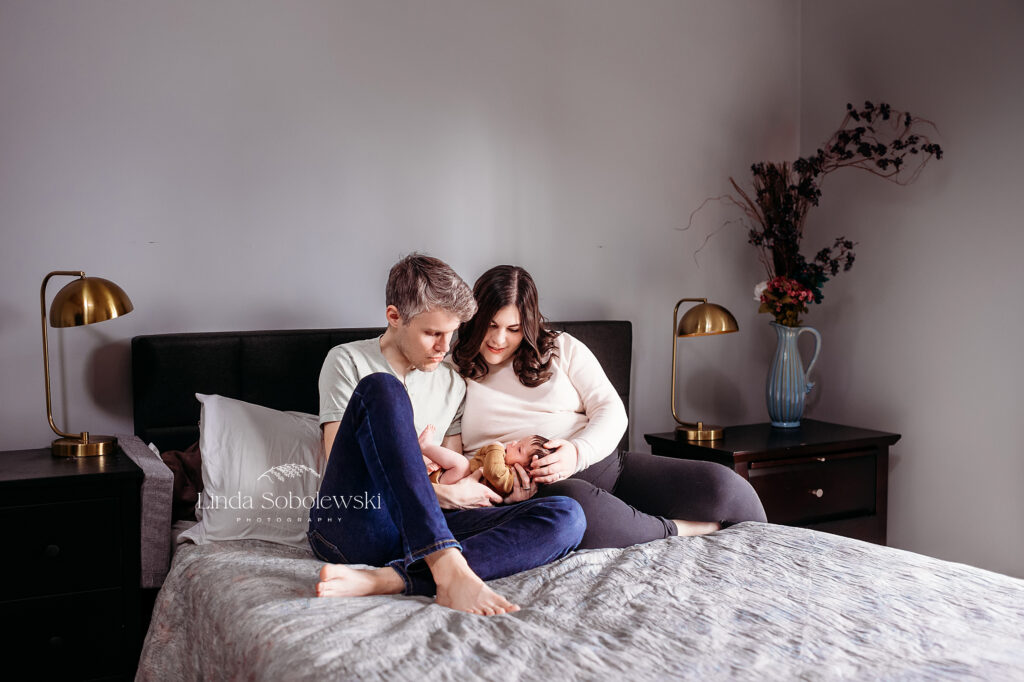 family of three sitting in bed, Branford CT newborn photography session