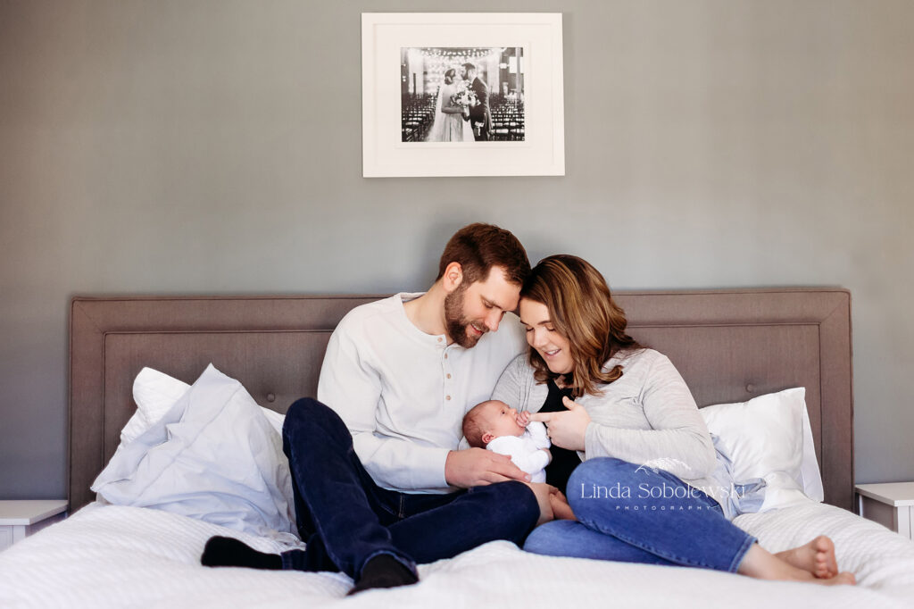 mom, dad and new baby in bed together, CT Newborn photographer