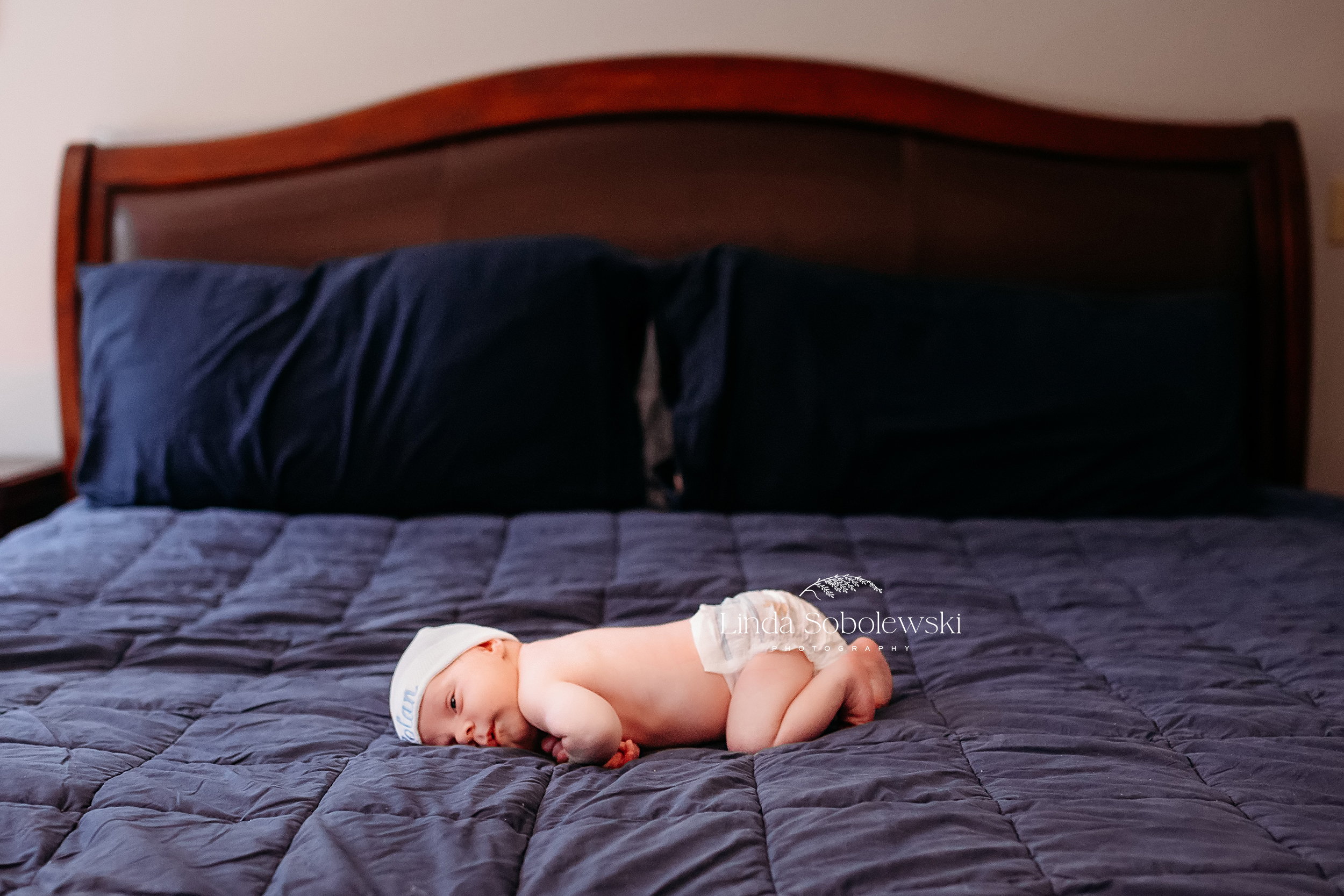 newborn baby laying in the middle of a bed, CT family and senior photographer