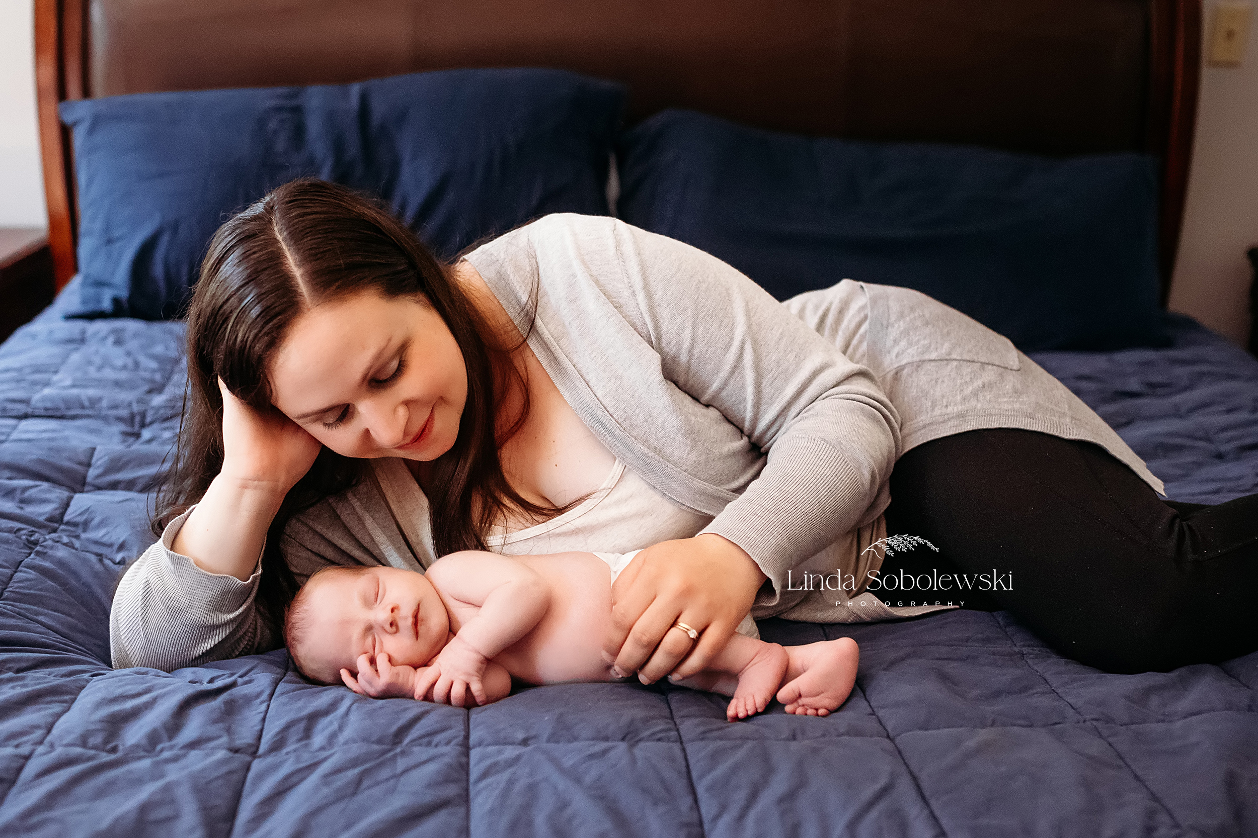 mom laying in bed with her baby boy, CT newborn and baby photographer