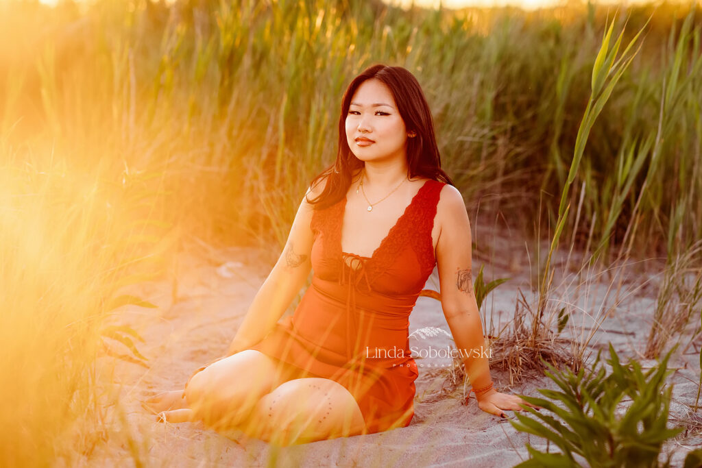 girl in red dress in the grass at the beach, Madison CT Graduation photographer