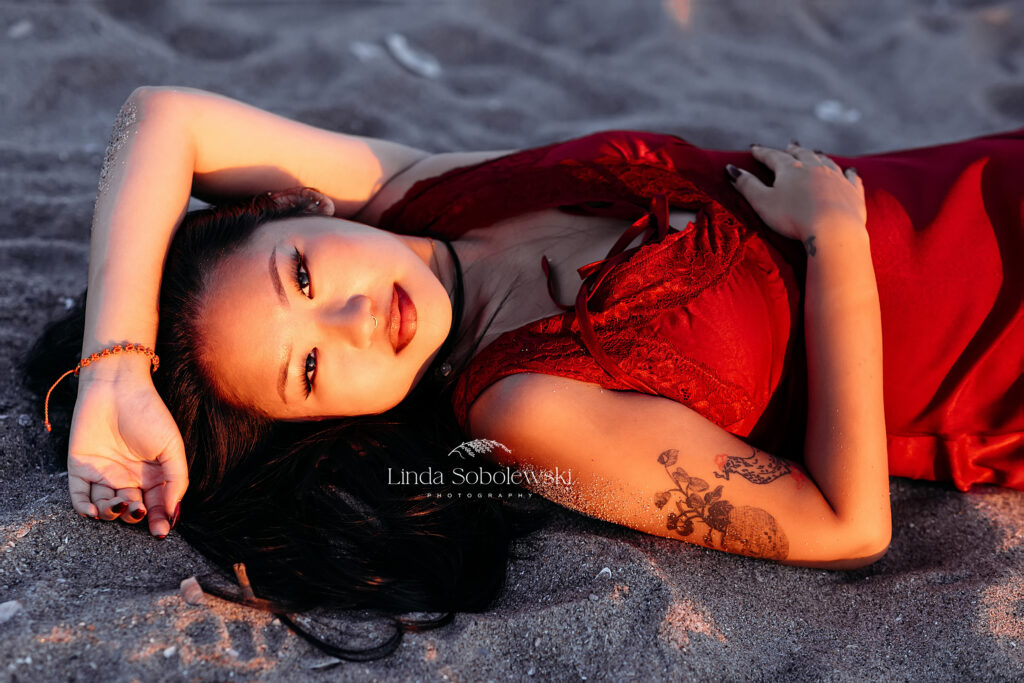 girl in red dress laying in the sand, Madison Connecticut photographer