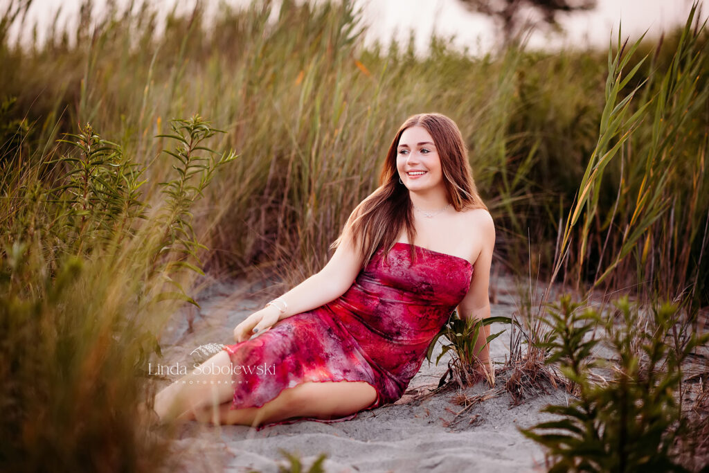 teenage girl with long hair sitting in beach grasses, Old Saybrook CT photographer