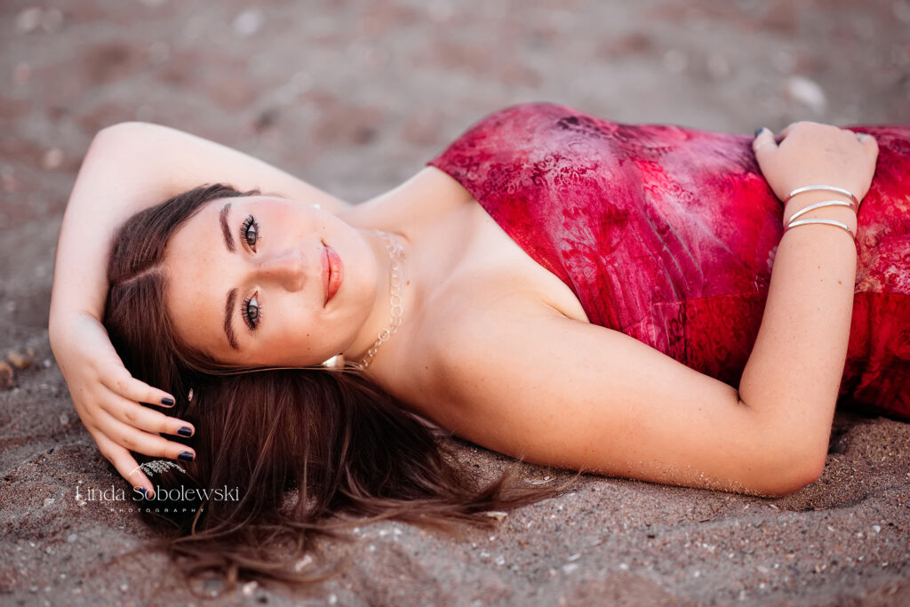 girl laying on the sand at the beach, Hammonasset Senior Photo Session, Westbrook CT photographer