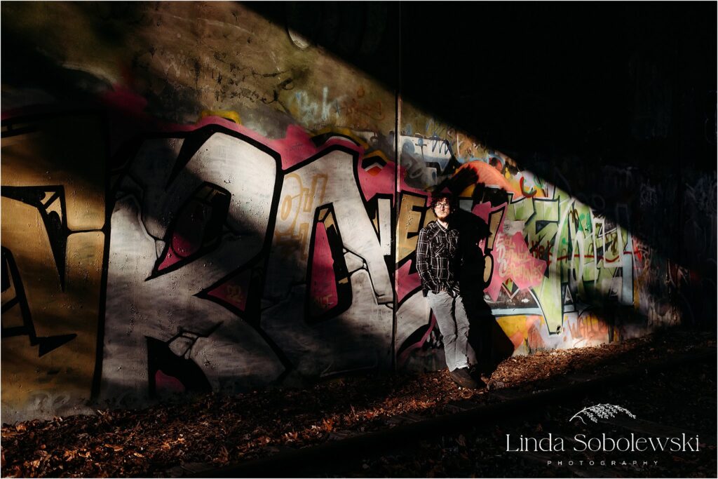 Teenage boy standing in the light under a bridge, CT Best senior photographer, 2024 Session Superlatives