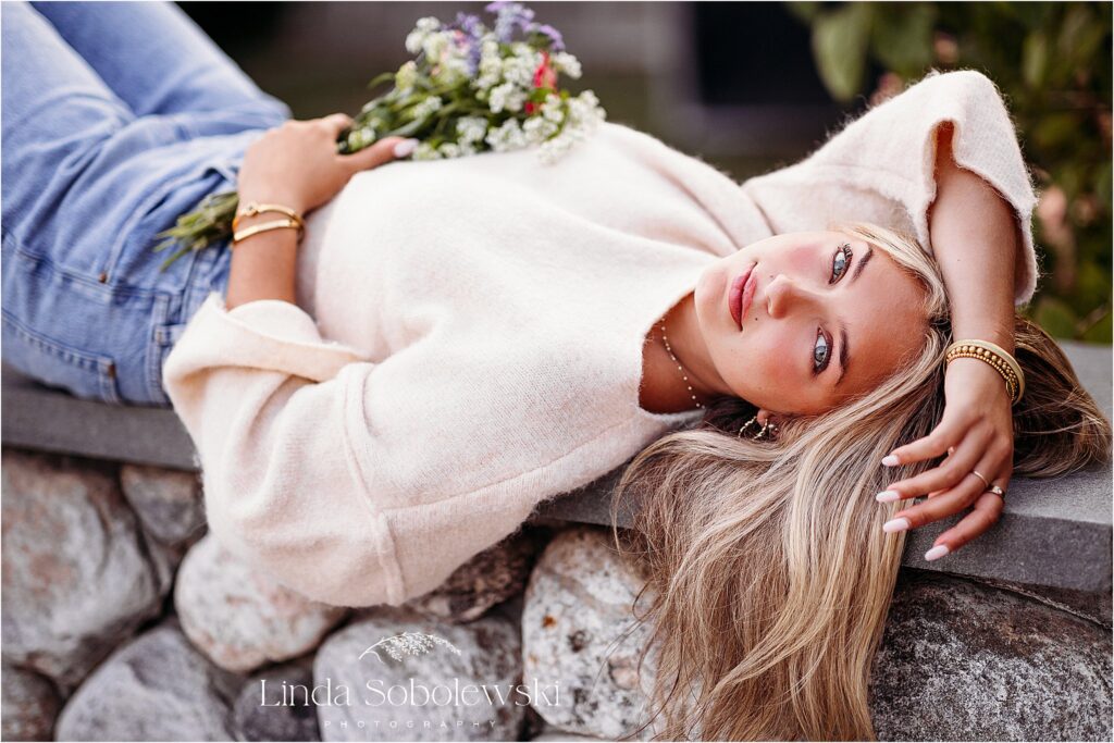 girl laying on a stone wall, Connecticut Senior Photographer