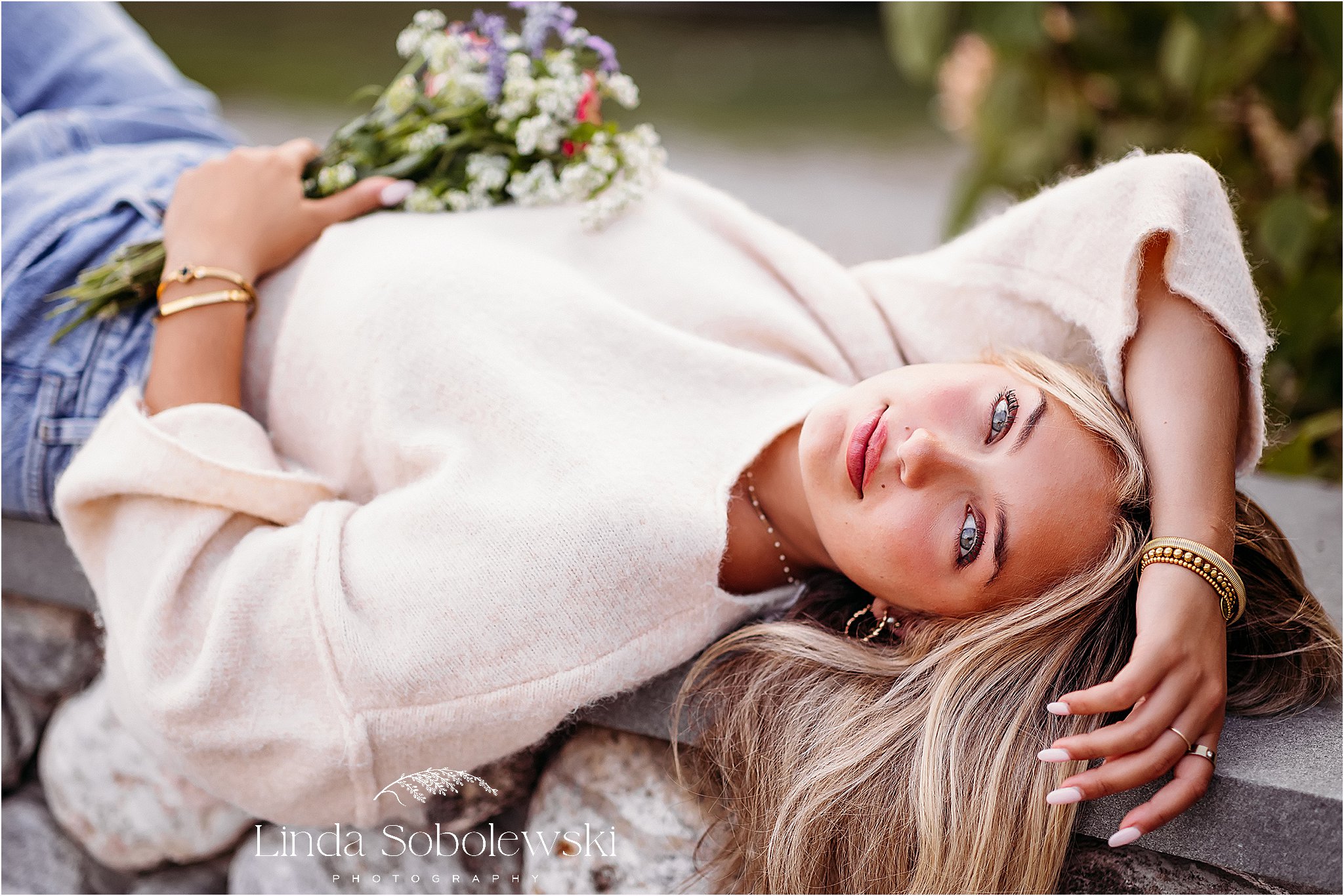 girl with long blonde hair laying on a stone wall, Guilford and Madison CT photographer