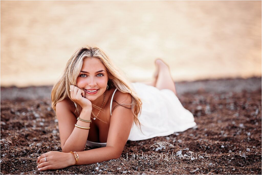 girl in white dress laying on the beach, Connecticut Senior Photographer