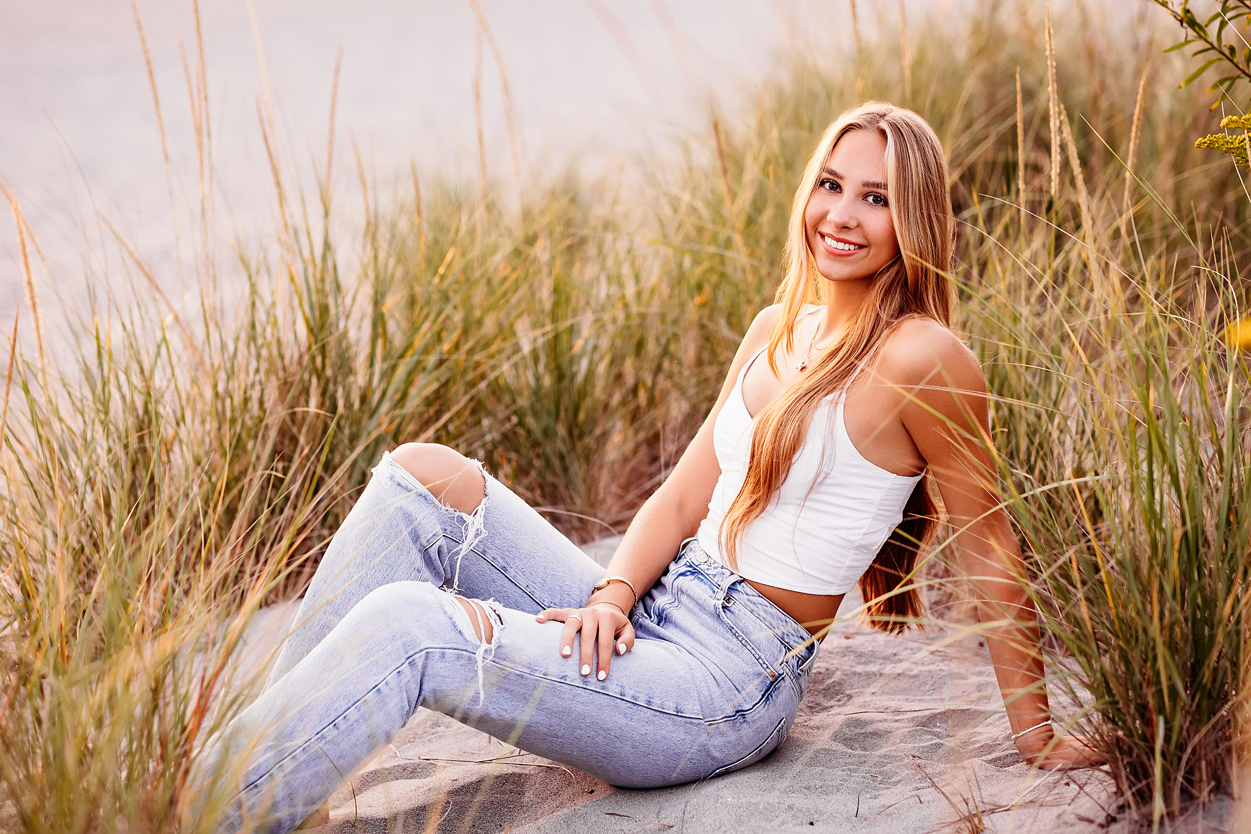 teenage girl with long hard sitting in the grass for her CT Senior Beach Session, Madison CT Senior photographer