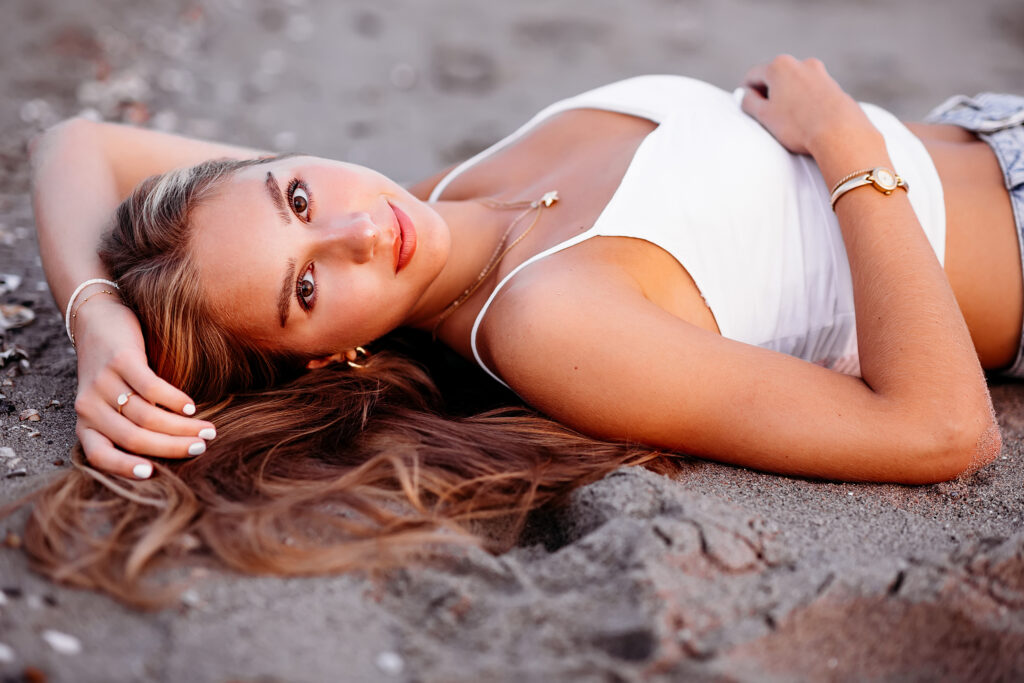 blonde teenage girl laying down at the beach, CT Senior Beach Session with Best CT photographer