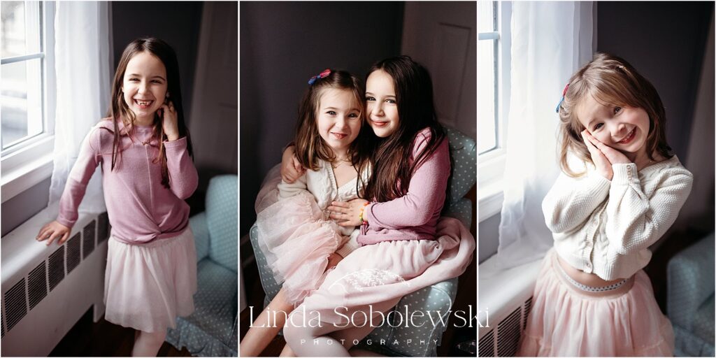 Three young sisters sharing giggles and sweet expressions near a window, showing their close bond in this heartwarming lifestyle session.