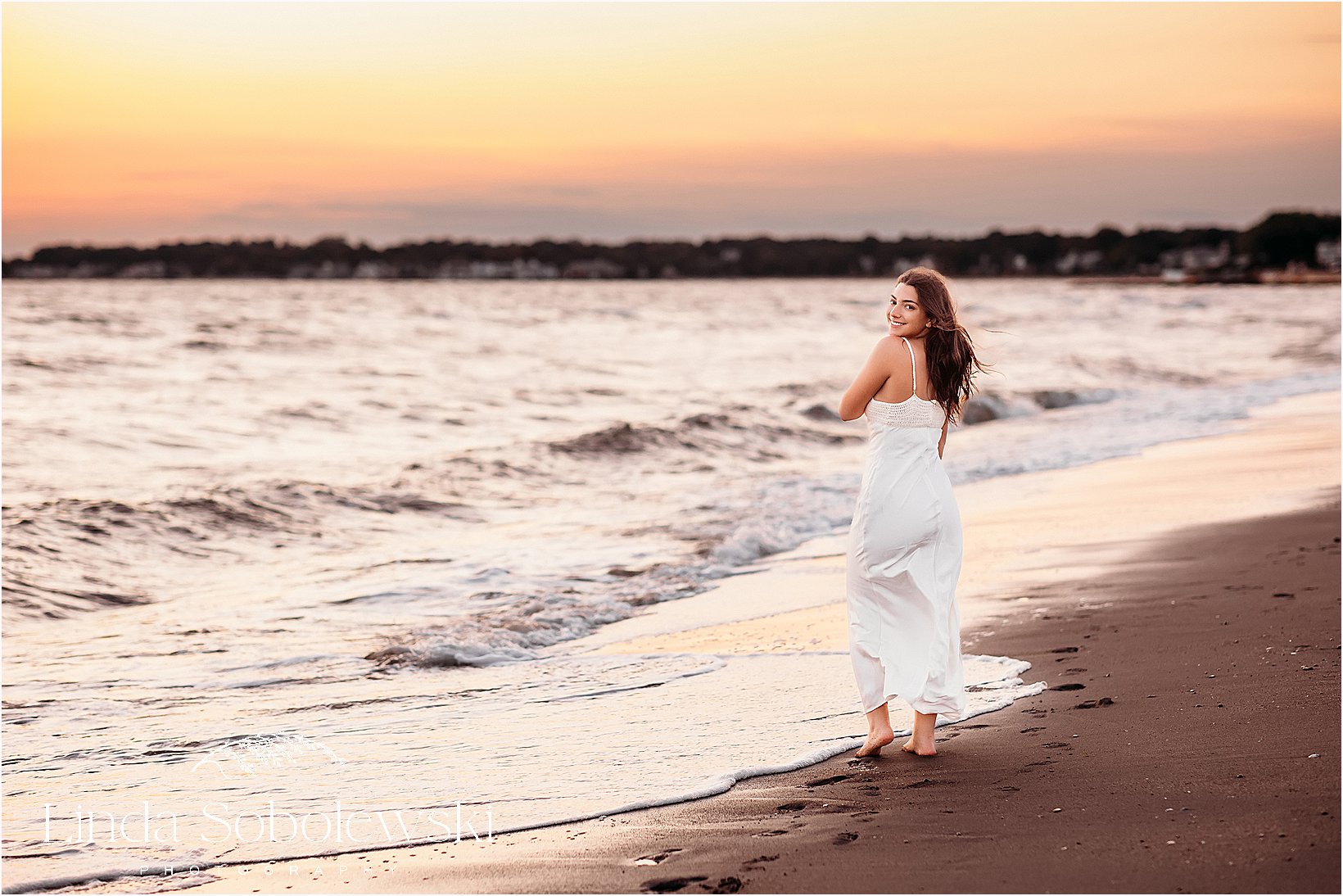 A CT senior session highlighting the warm glow of the sunset, featuring a senior girl in a flowing white dress.