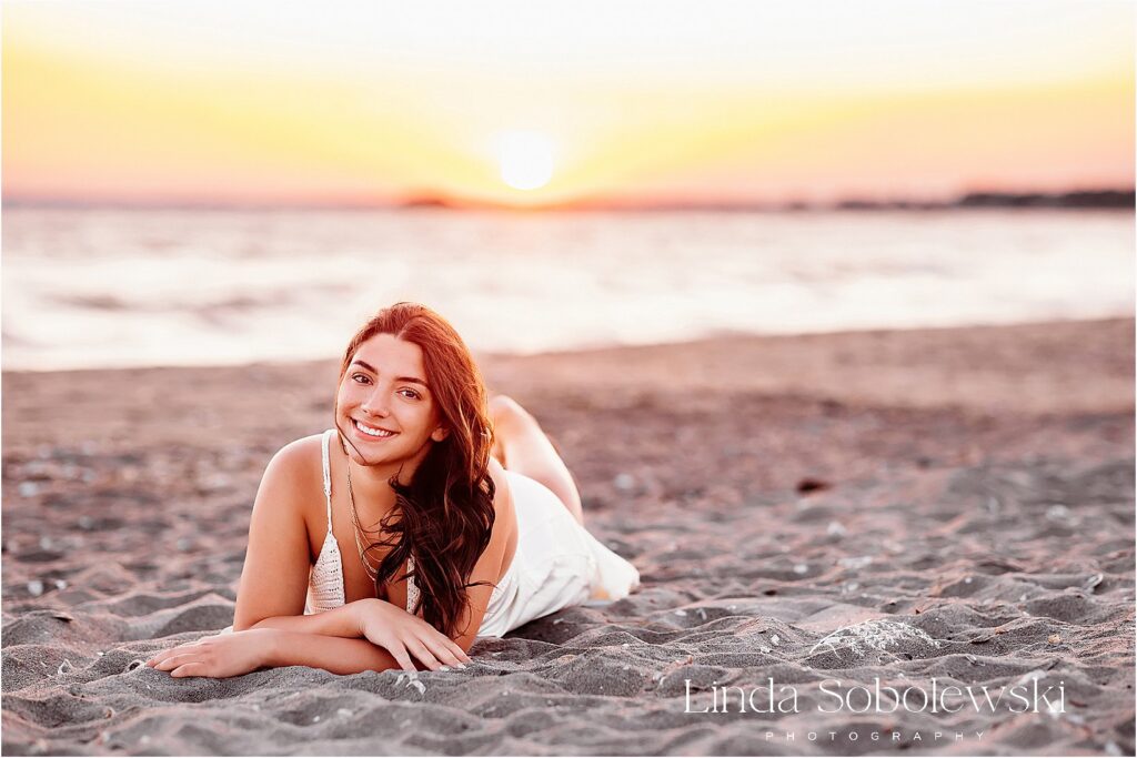 A coastal senior session featuring relaxed, natural poses in the sand, capturing the beauty of beachside senior portraits.