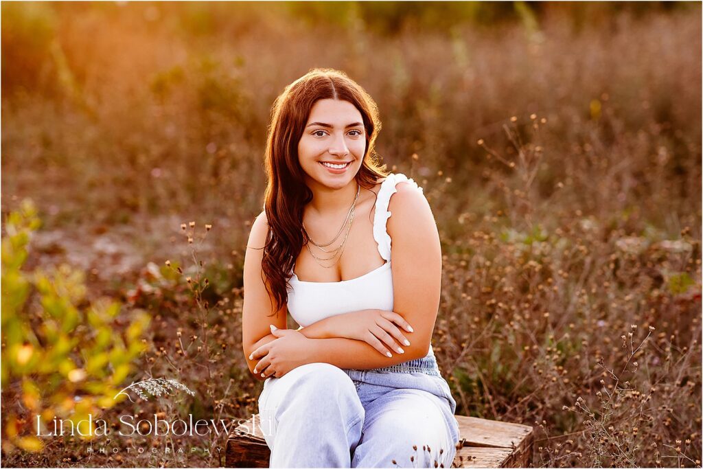 A senior session in Madison, CT, featuring golden-hour light and a natural outdoor setting for timeless portraits.