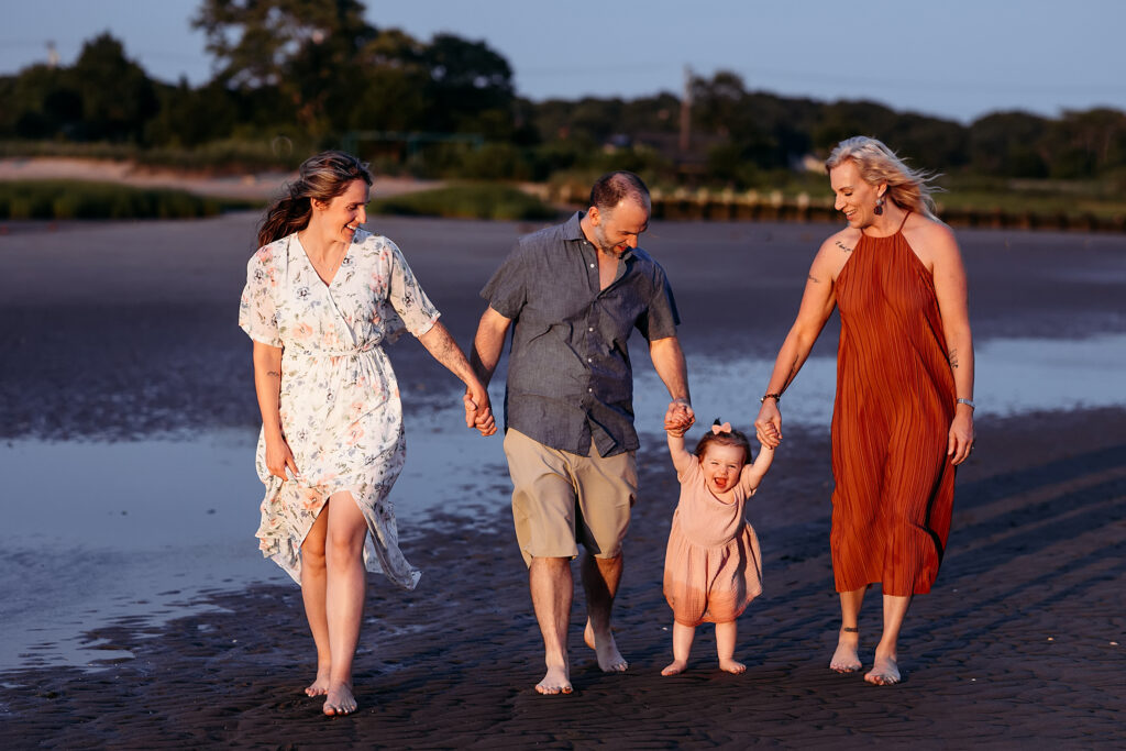 Extended family walking barefoot on the beach during an evening photo session