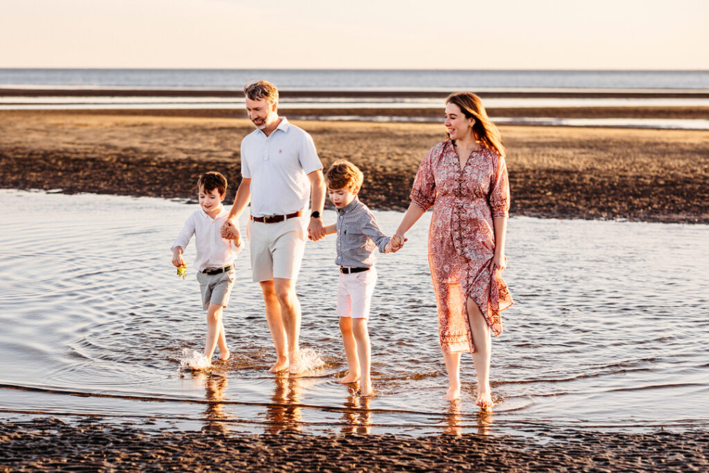 family of four walking in the waves for a summer petite session 2026 CT Shoreline family photographer