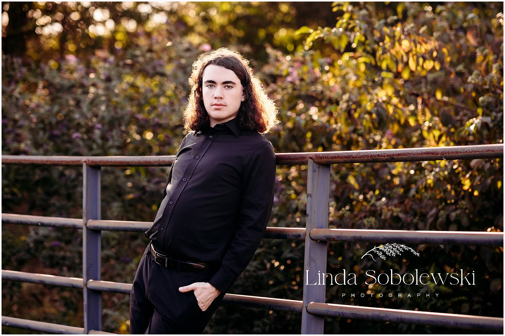 Senior boy portraits in Connecticut featuring a high school senior in an all black outfit with warm backlight, CT senior photographer