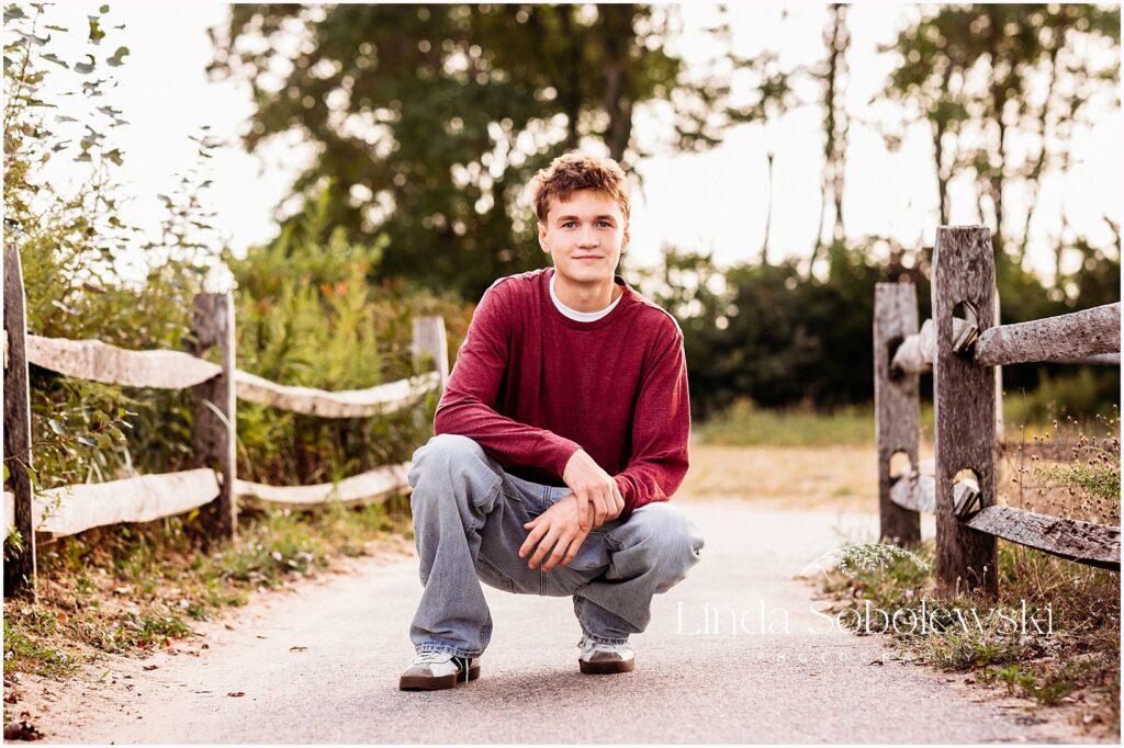 Casual senior portrait of a high school senior boy photographed outdoors in soft natural light, Connecticut shoreline
