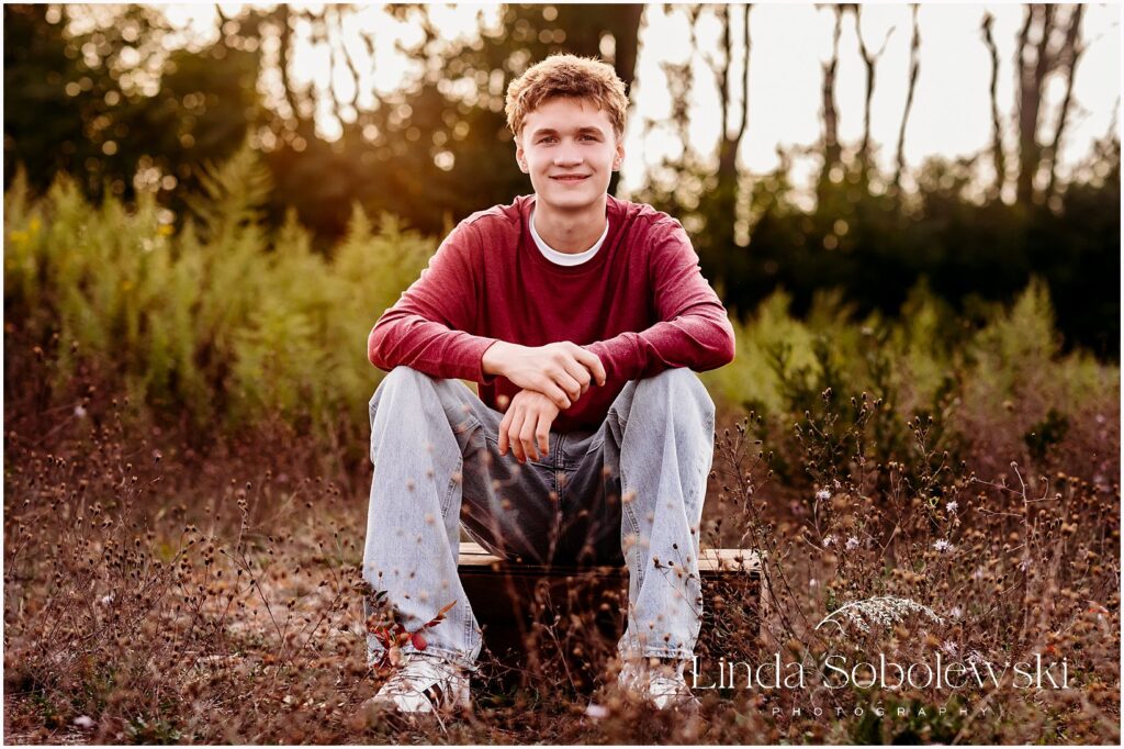 High school senior boy portraits captured in golden hour light during a relaxed outdoor session in Connecticut, Connecticut shoreline