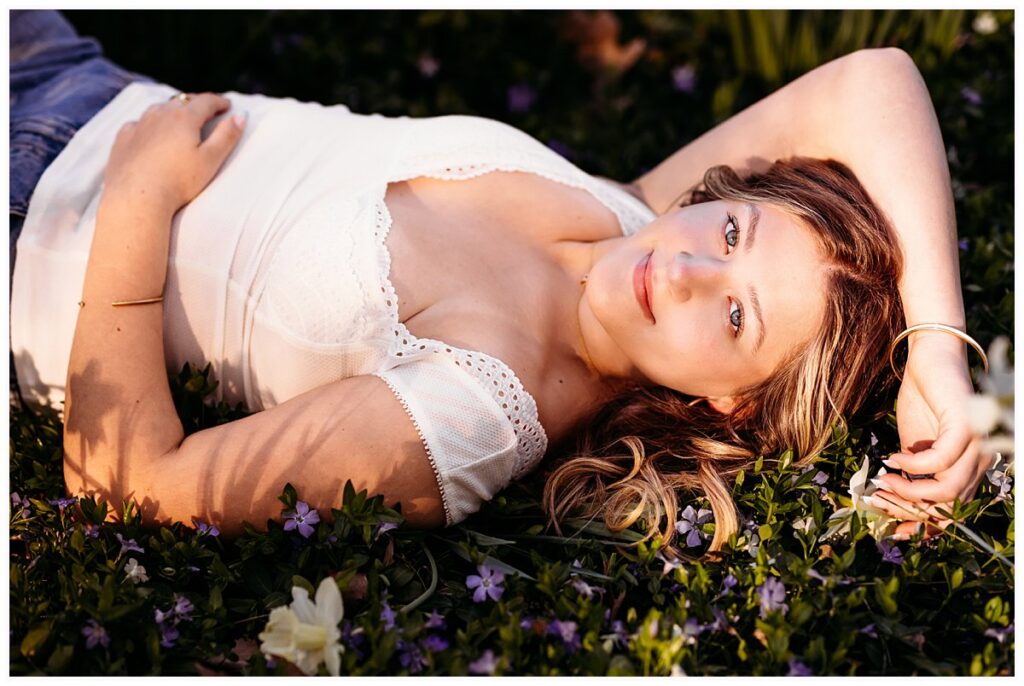 senior portrait at Elizabeth Park, girl lying in purple flowers at golden hour