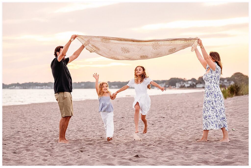 family of four having fun on the beach,CT Family photographer