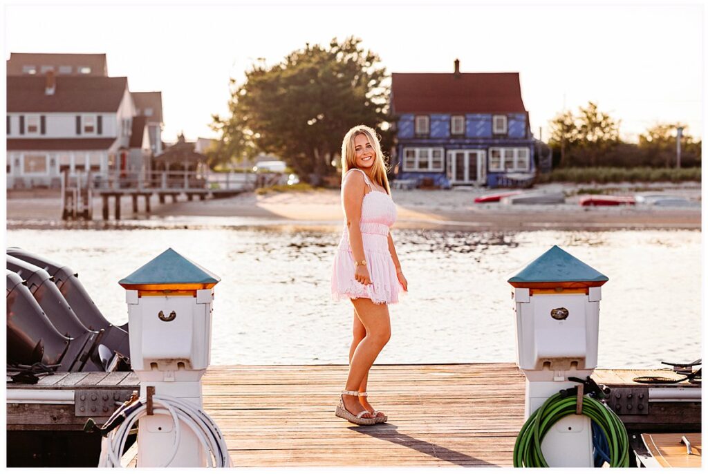 Old Saybrook Senior Session on a Boat featuring Elle in a pink summer dress on a waterfront dock. CT senior photographer